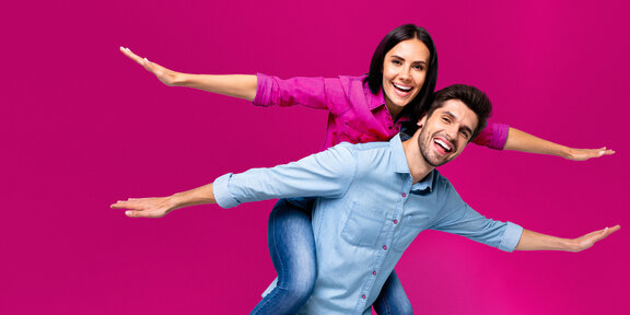 Junge Zahnärztin und Zahnarzt vor magenta Hintergrund, symbolisieren Austausch bei Praxisgründung